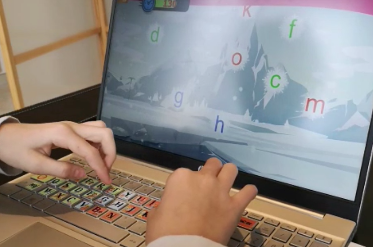 Stickers collés sur les touches d'un clavier et enfant tapant