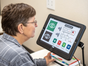 personne communiquant avec une tablette munie d'une commande oculaire